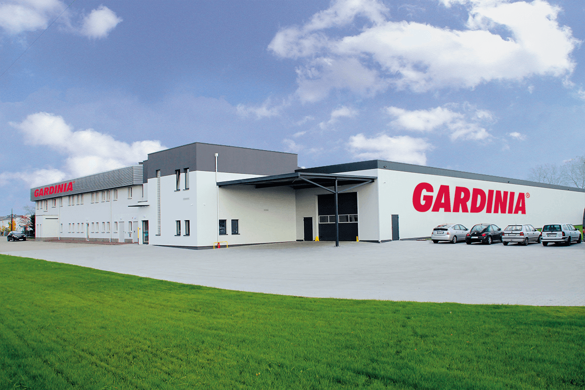 Exterior view of a modern company building with large lettering reading “Gardinia.” The image shows the company's location with production and logistics areas and gives an impression of the size and infrastructure of the company.
