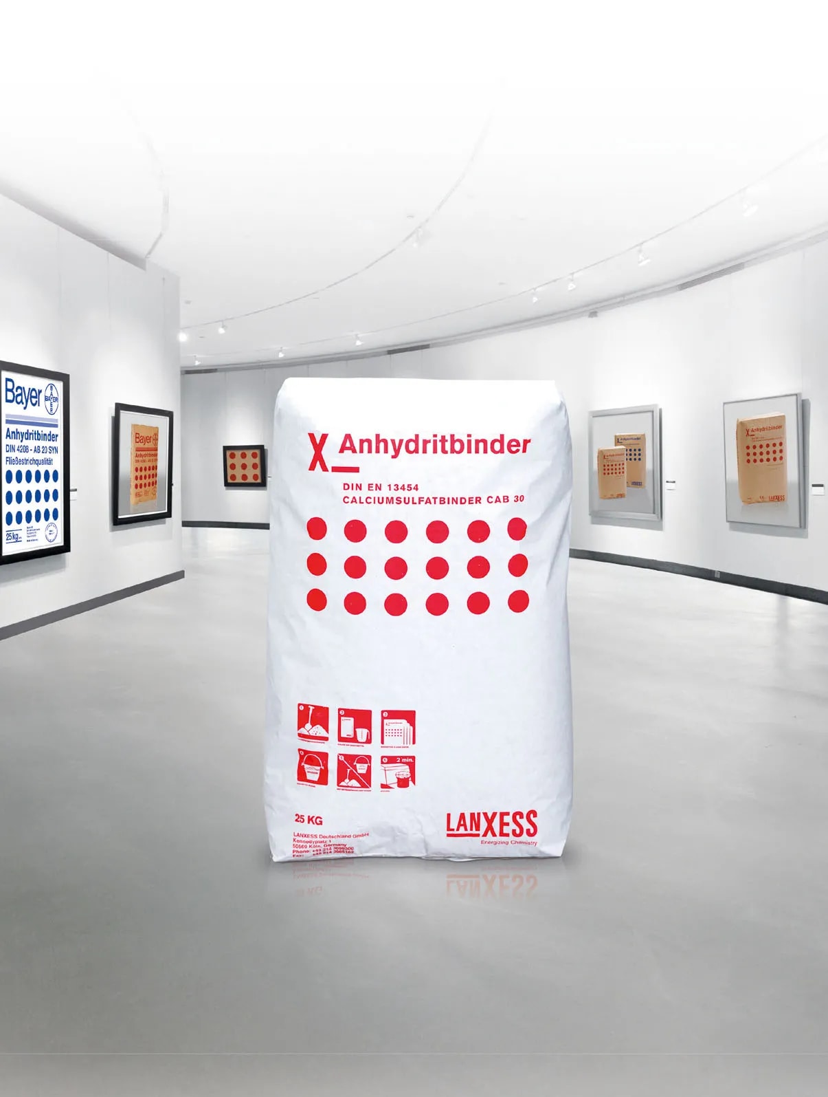 Product presentation of an anhydrite binder by LANXESS. The bag with red lettering is placed centrally in a bright, gallery-like space, highlighting the product’s premiere at DOMOTEX.
